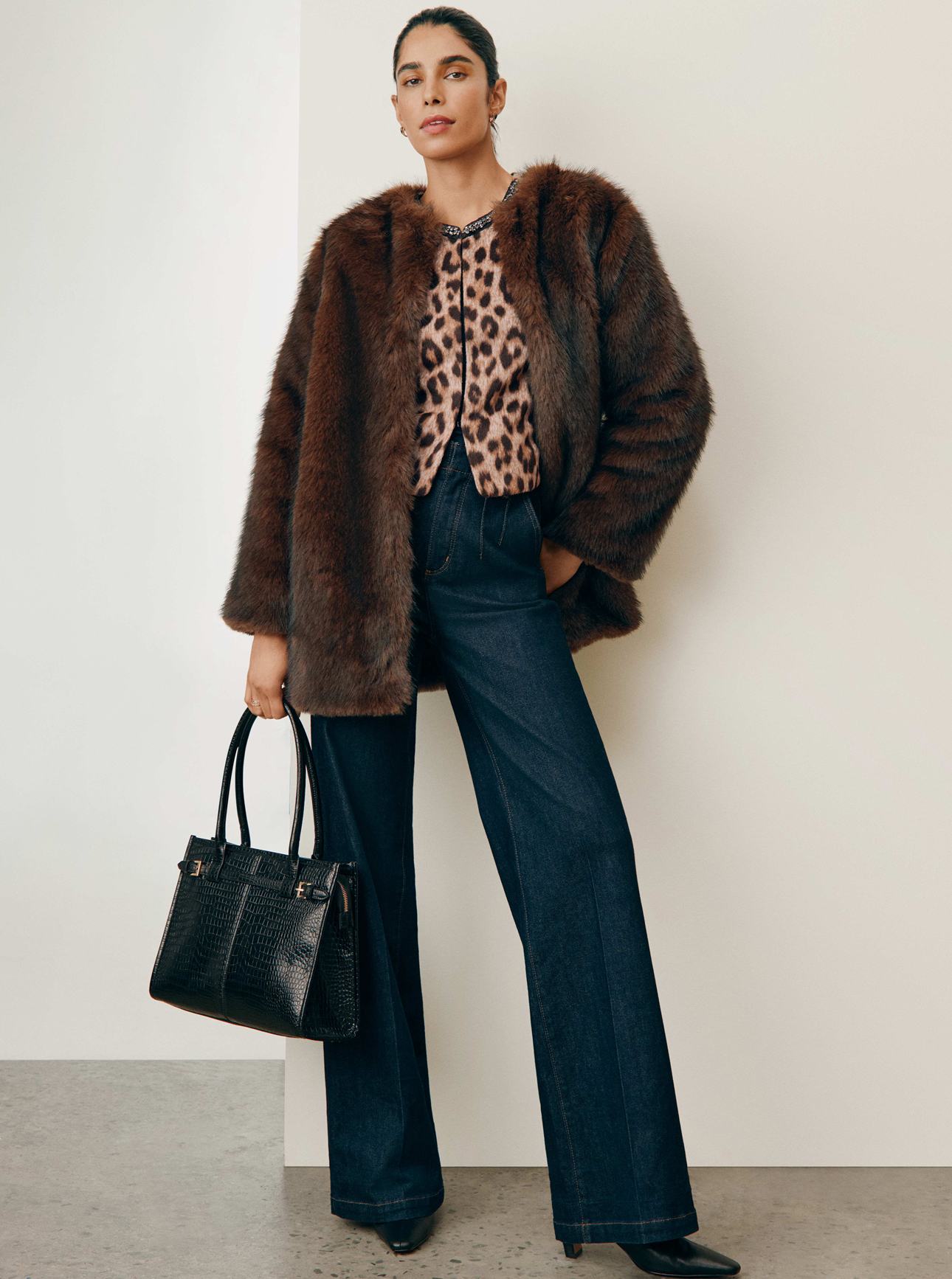 Trending Layers — a model in a faux fur coat over a leopard top and dark jeans. Shop New Outerwear.