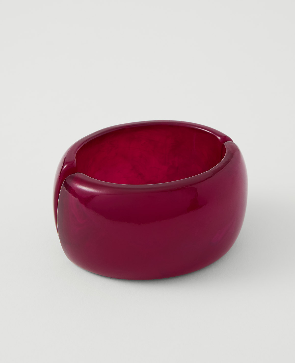 A glossy, deep red, chunky bracelet rests on a plain white background.