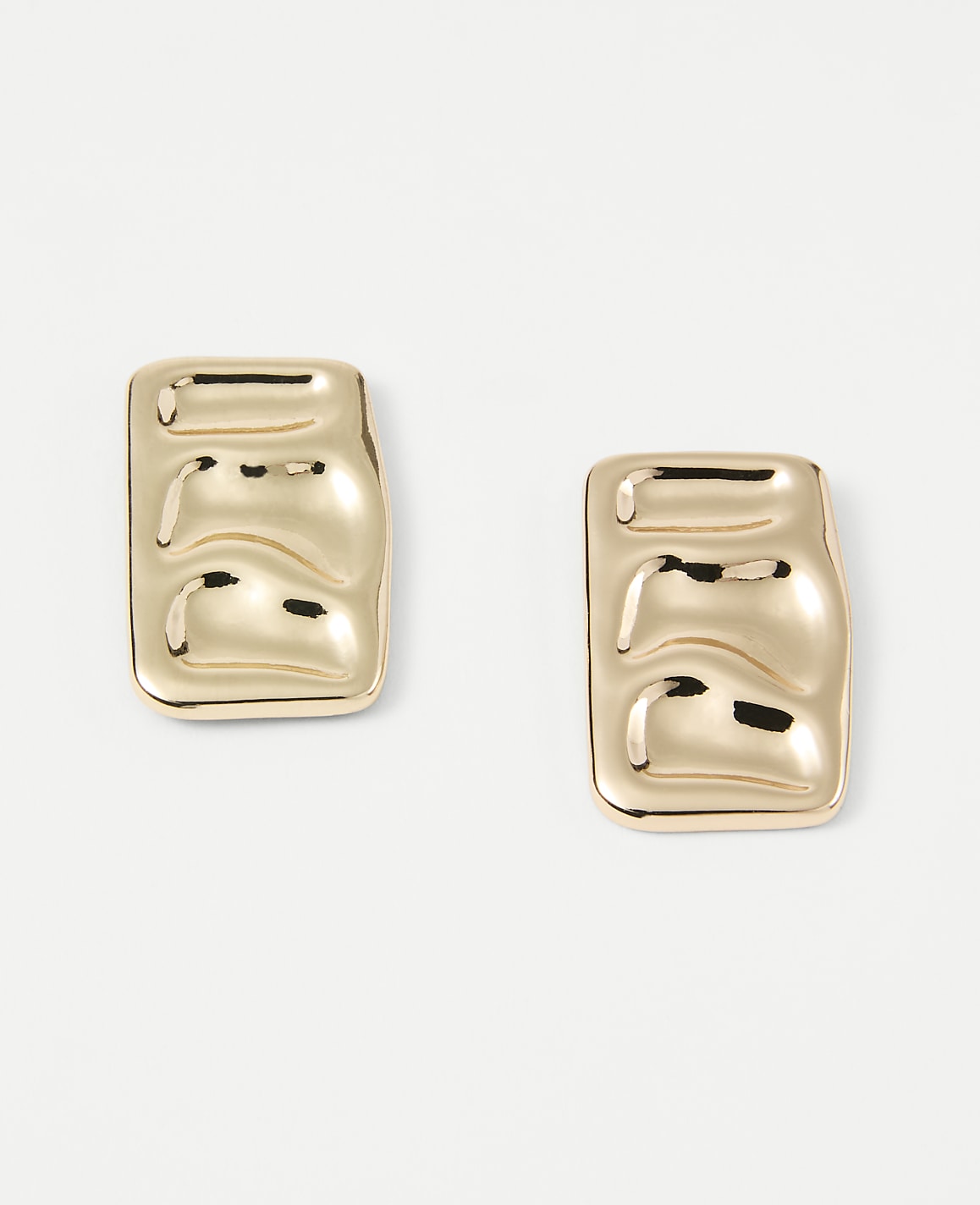 Two gold rectangular earrings with a textured surface rest on a plain white background.