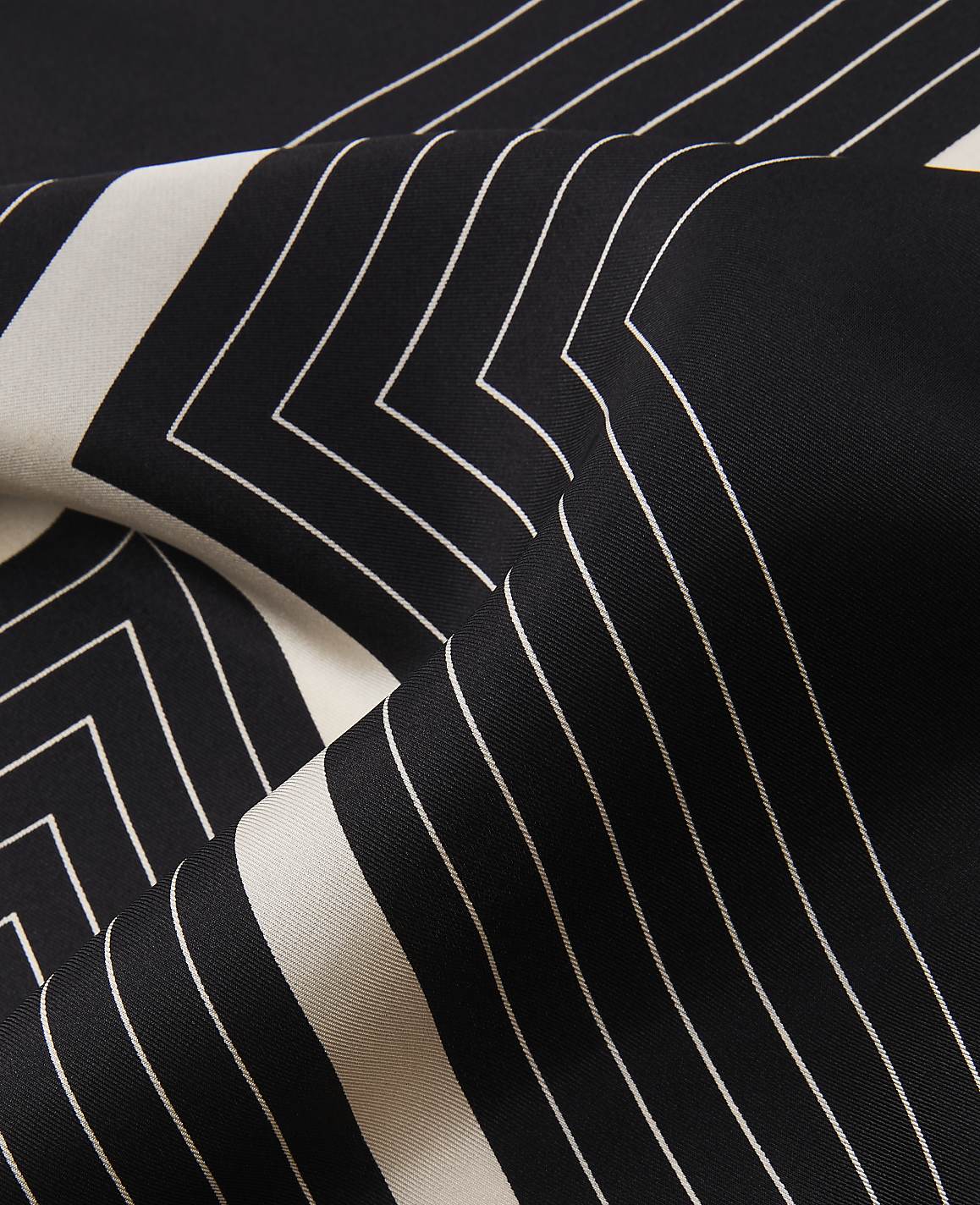 A black and white patterned fabric folds in the foreground, with a continuation of the geometric design visible in the background.