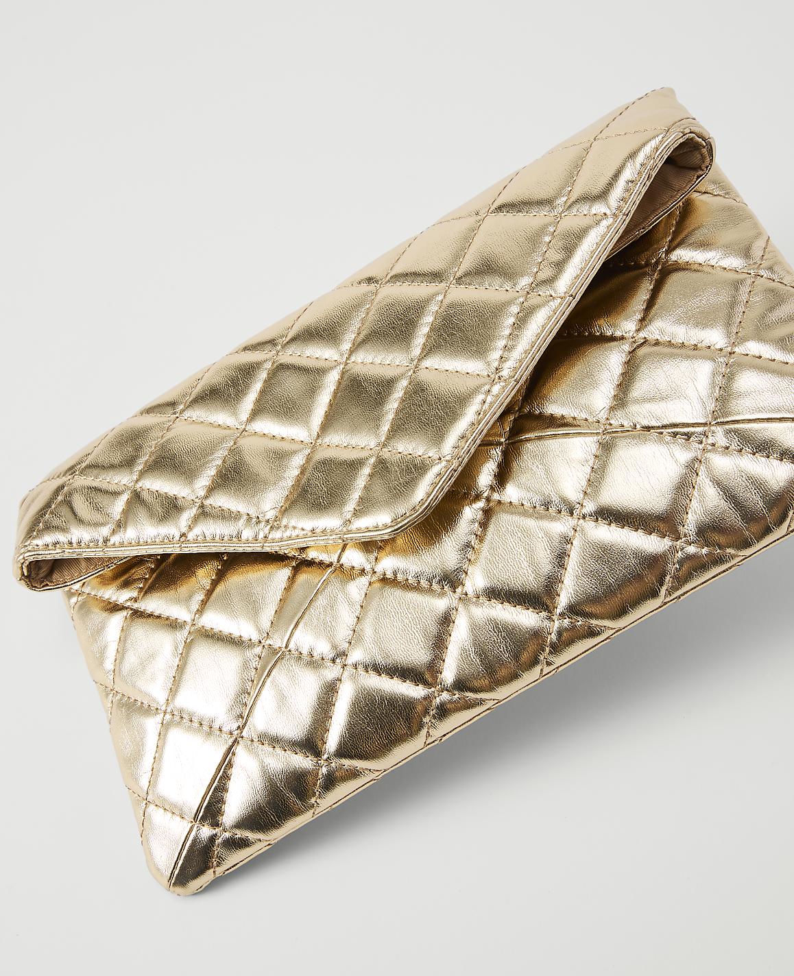 A gold quilted clutch rests on a plain white background.