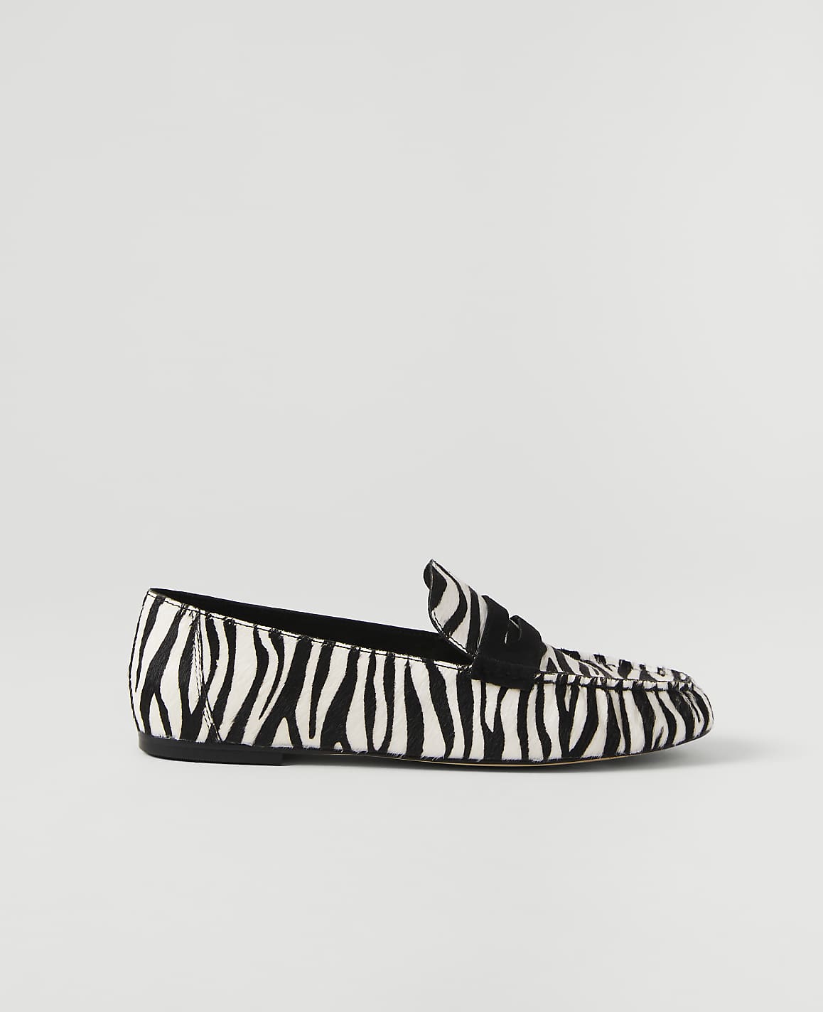 A zebra-print loafer rests on a plain white background.