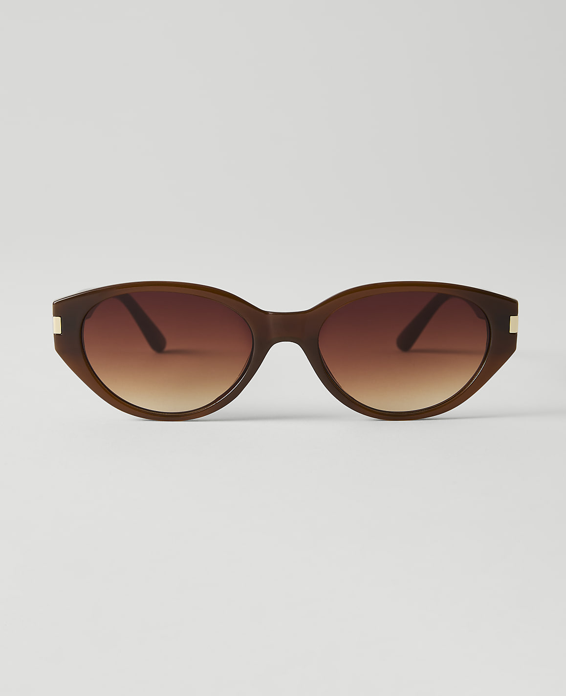 Brown oval sunglasses with gradient lenses are centered against a plain white background.