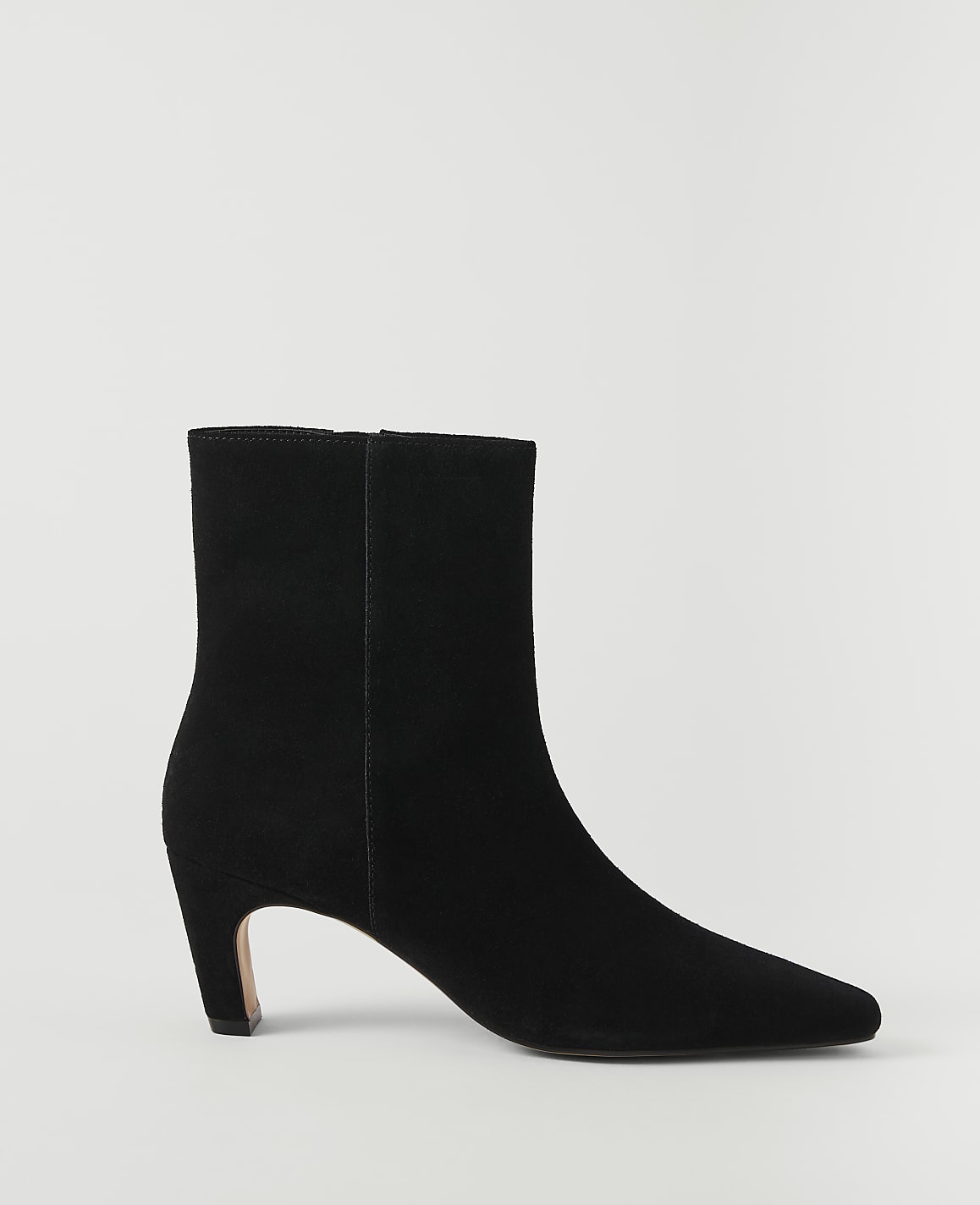 A black suede ankle boot with a pointed toe and a low heel stands against a plain white background.