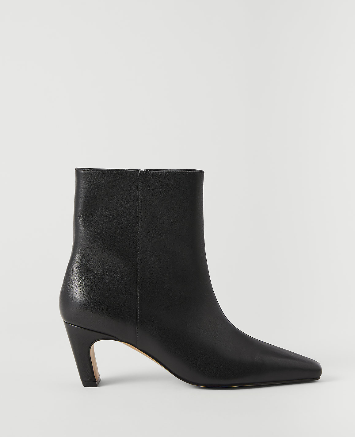 A black leather ankle boot with a pointed toe and a flared heel stands against a plain white background.