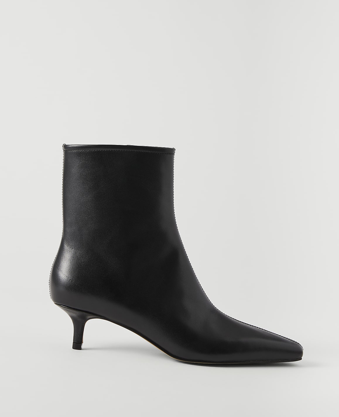 A sleek black leather ankle boot with a pointed toe and kitten heel stands against a plain white background.