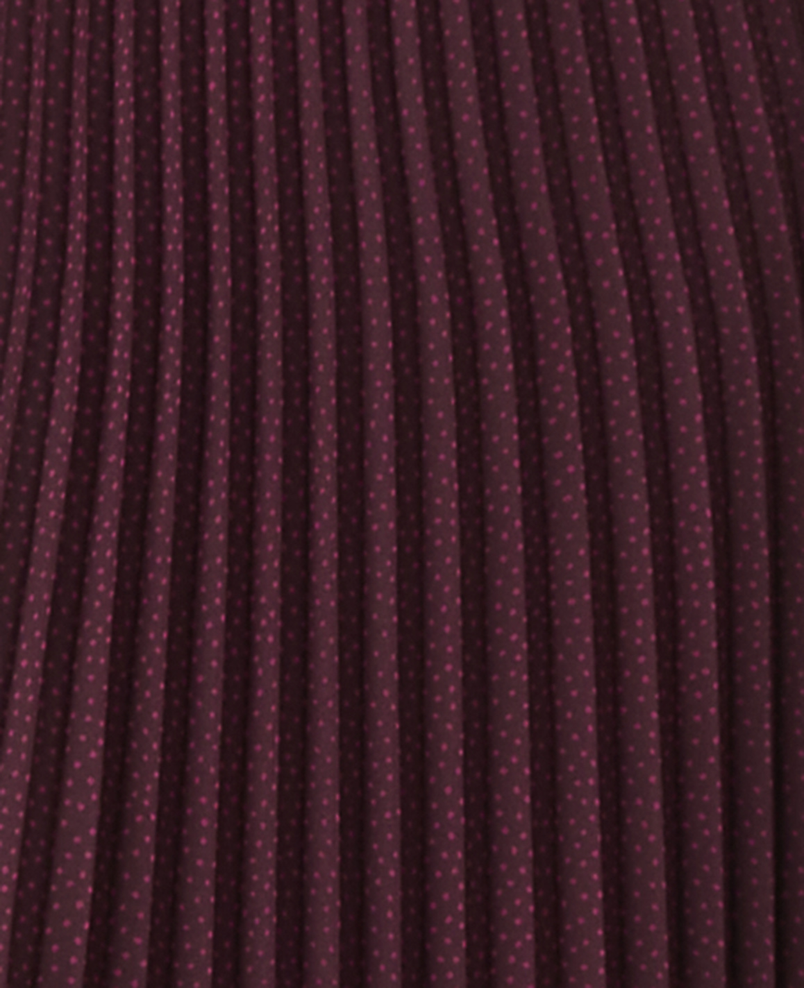 A close-up view of a burgundy pleated fabric with a subtle polka dot pattern fills the frame.