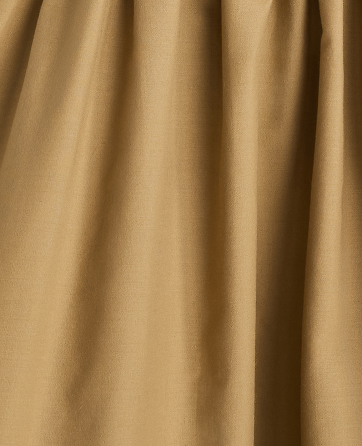A close-up of tan fabric with soft folds fills the frame, creating a textured, monochromatic background.