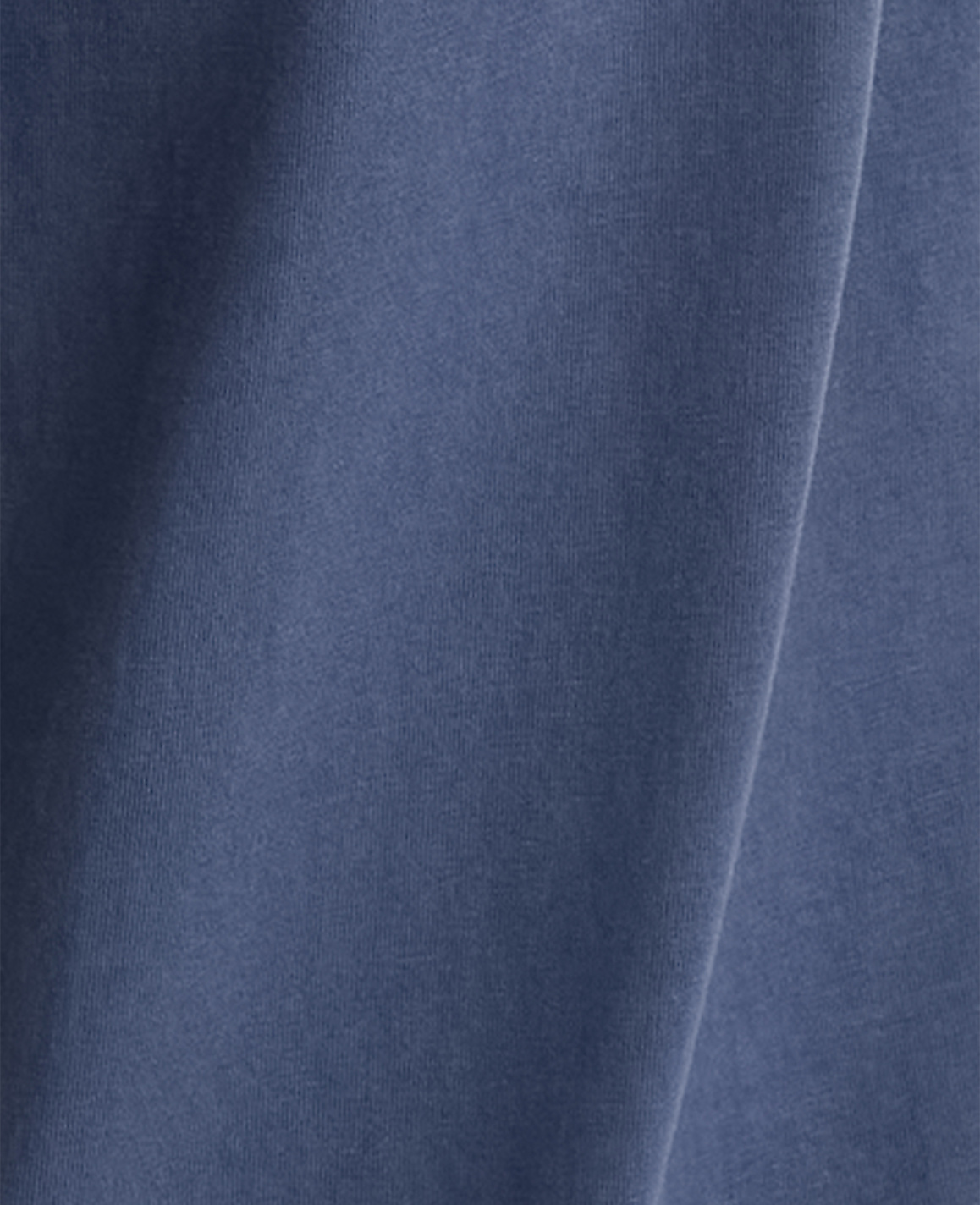 A close-up view of a wrinkled, blue fabric fills the frame, with soft shadows and highlights creating depth.