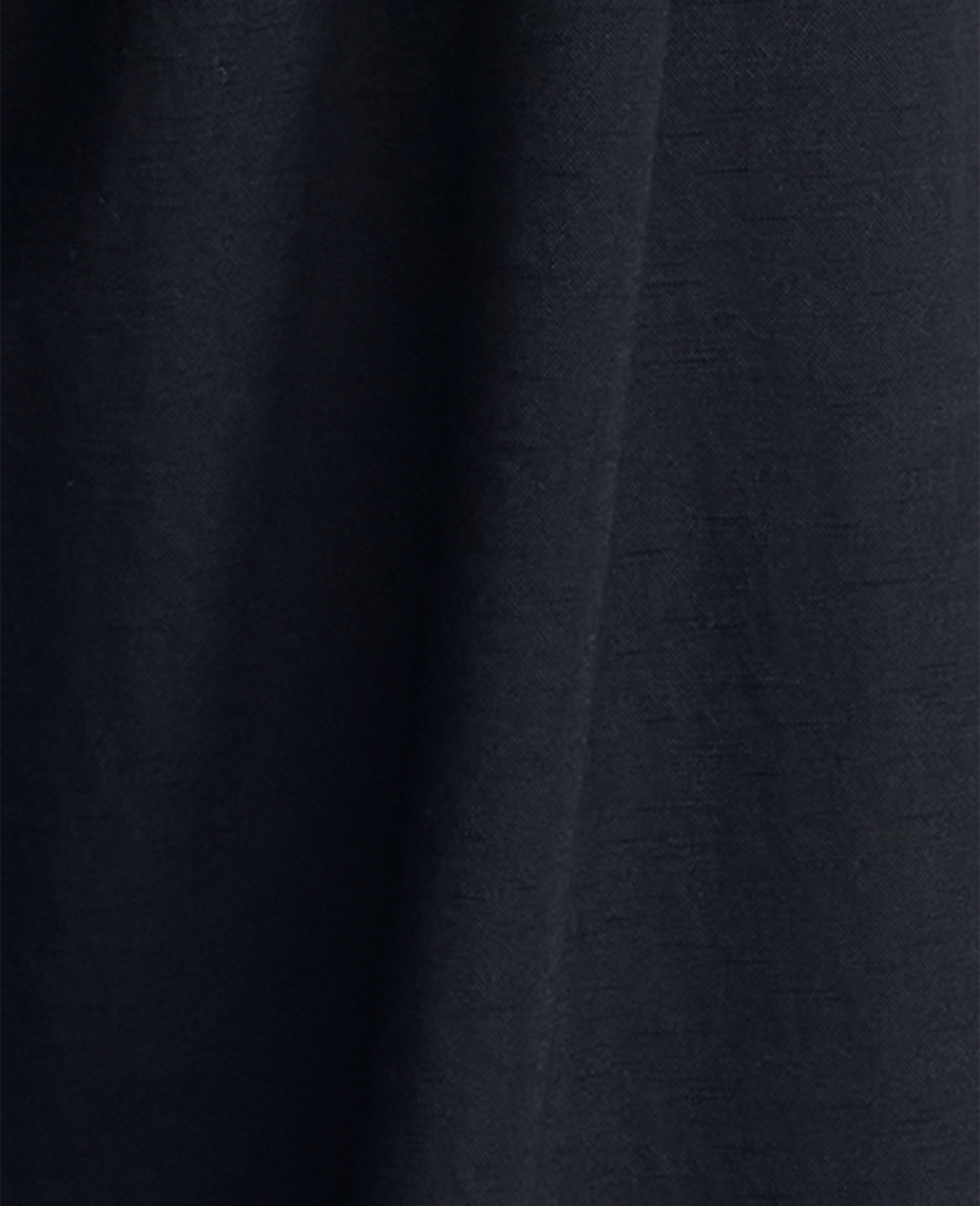 Dark blue fabric with subtle texture fills the frame, with soft folds creating shadows and highlights.