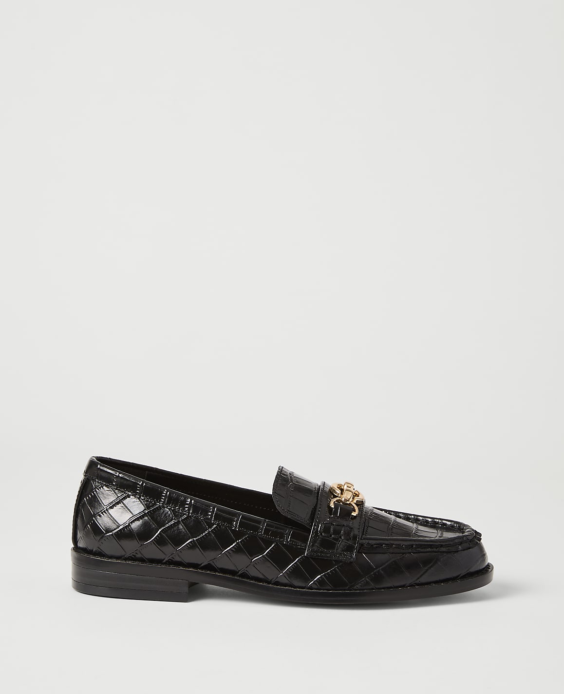 A black, crocodile-embossed loafer with a gold buckle sits on a plain white background.