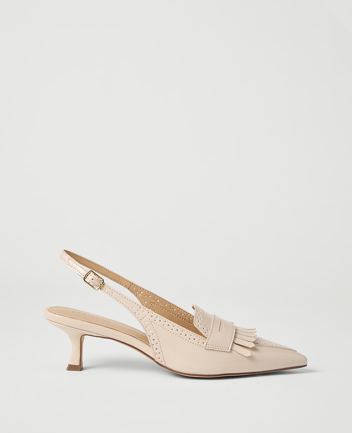 A light pink slingback loafer with fringe detailing rests on a plain white background.