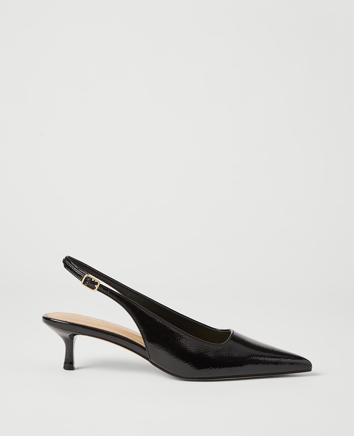 A black patent leather slingback heel with a pointed toe rests on a plain white background.