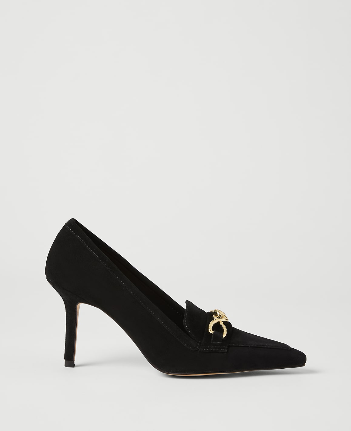 A black suede pump with a gold horsebit detail rests on a plain white background.