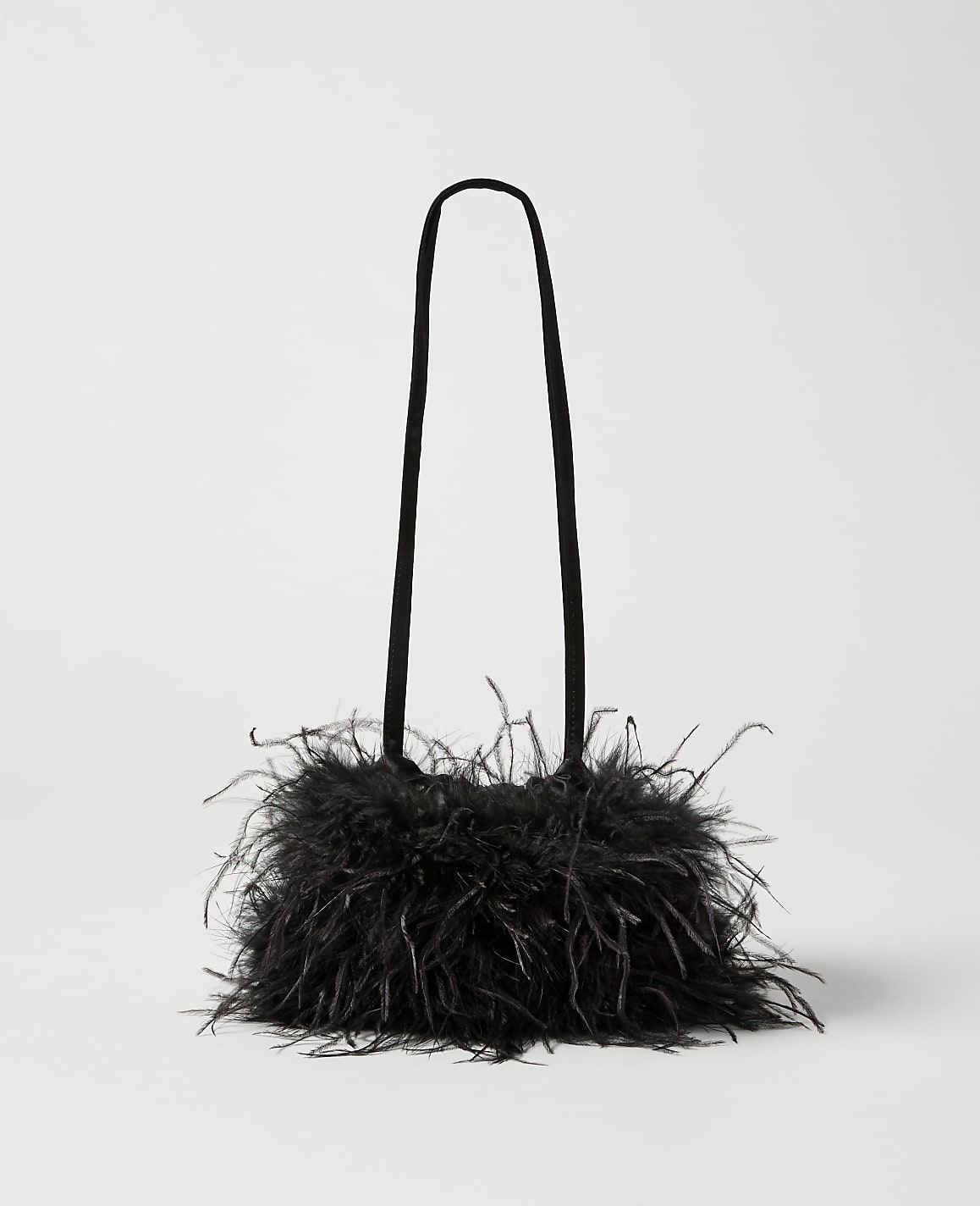 A black feathered handbag with thin straps rests against a plain white background.