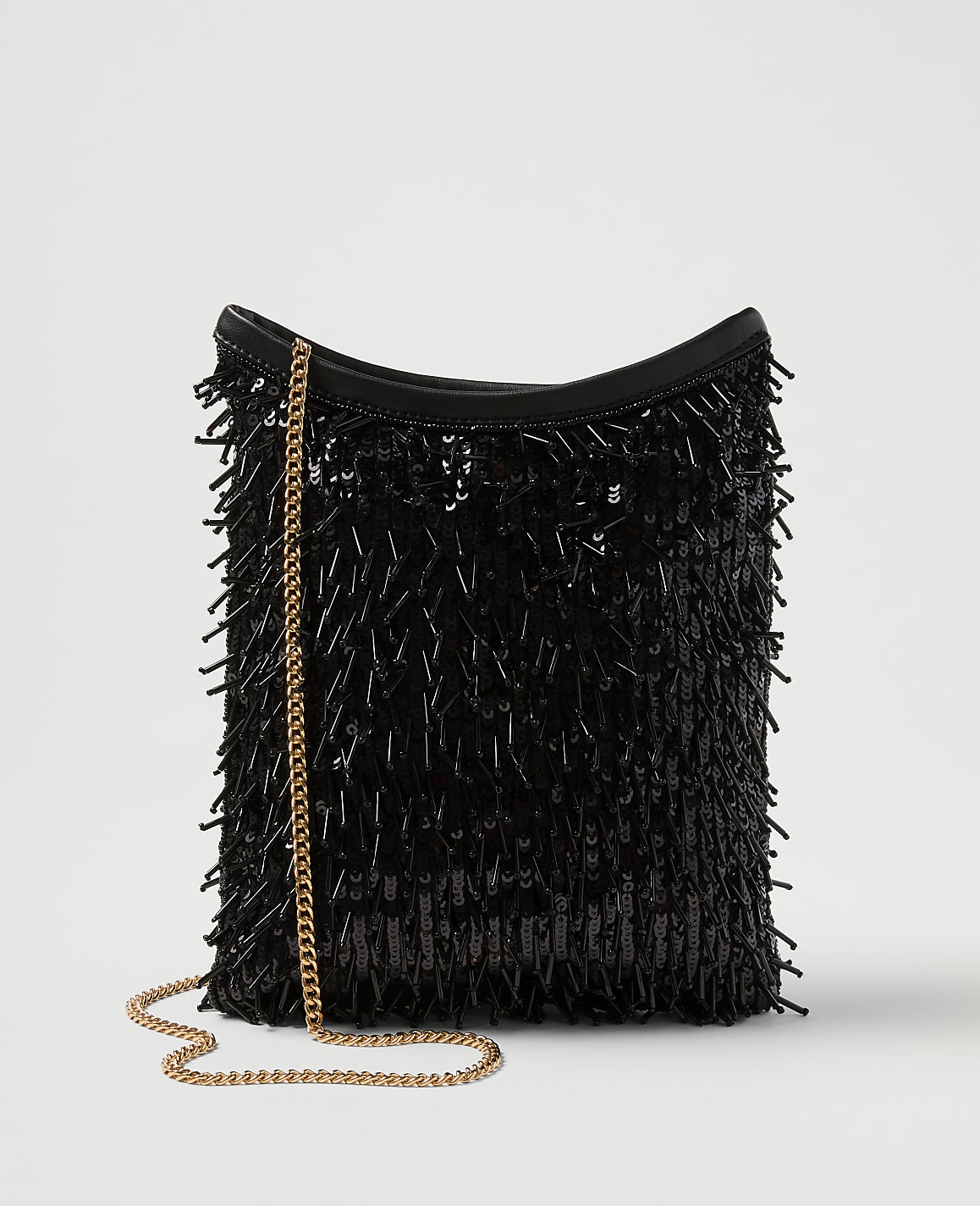 A black sequined fringe bag with a gold chain strap rests against a plain white background.