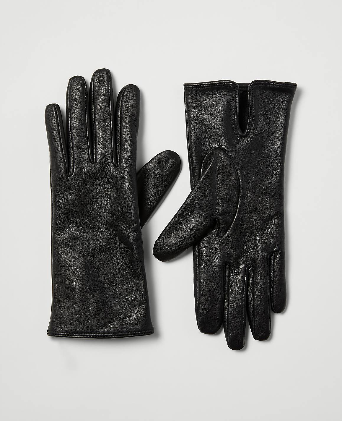 A pair of black leather gloves rests on a plain white background.