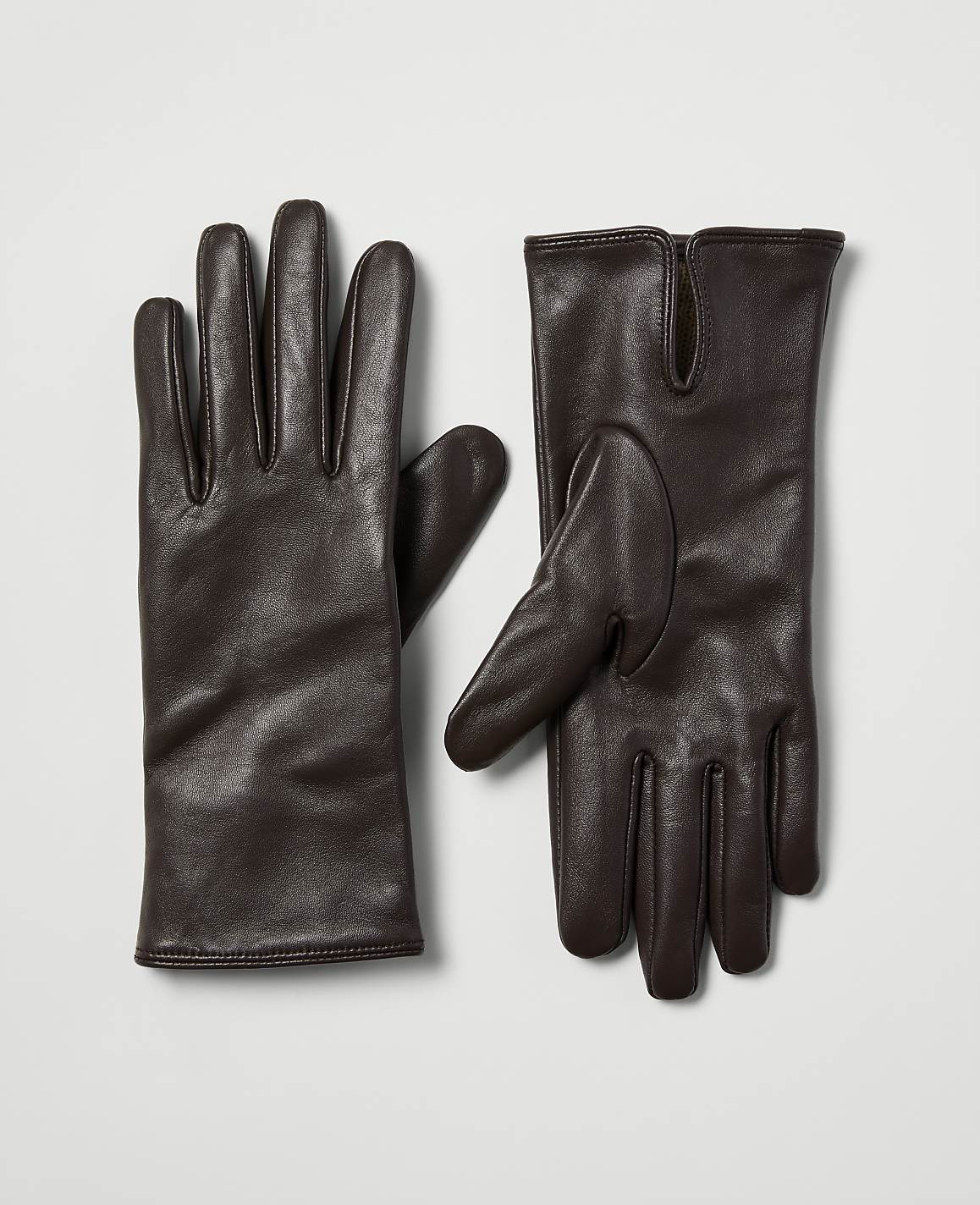 A pair of dark brown leather gloves lies on a plain, light gray background.