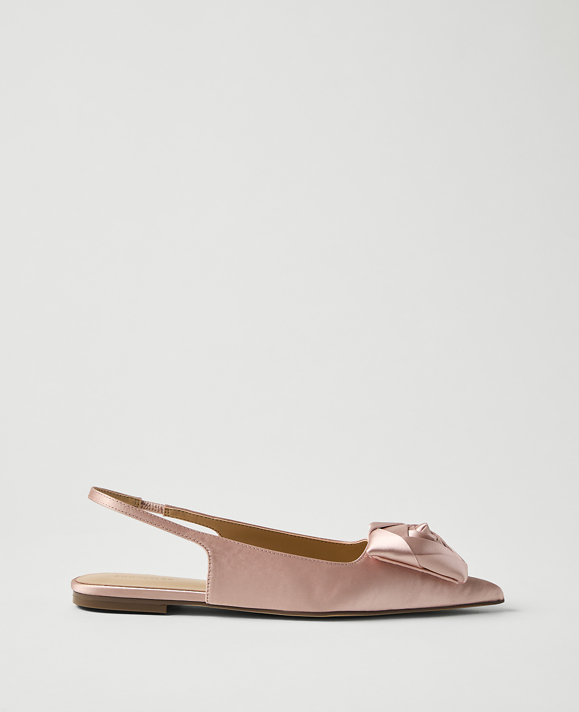 A single pink satin slingback flat with a bow detail sits against a plain light gray background.