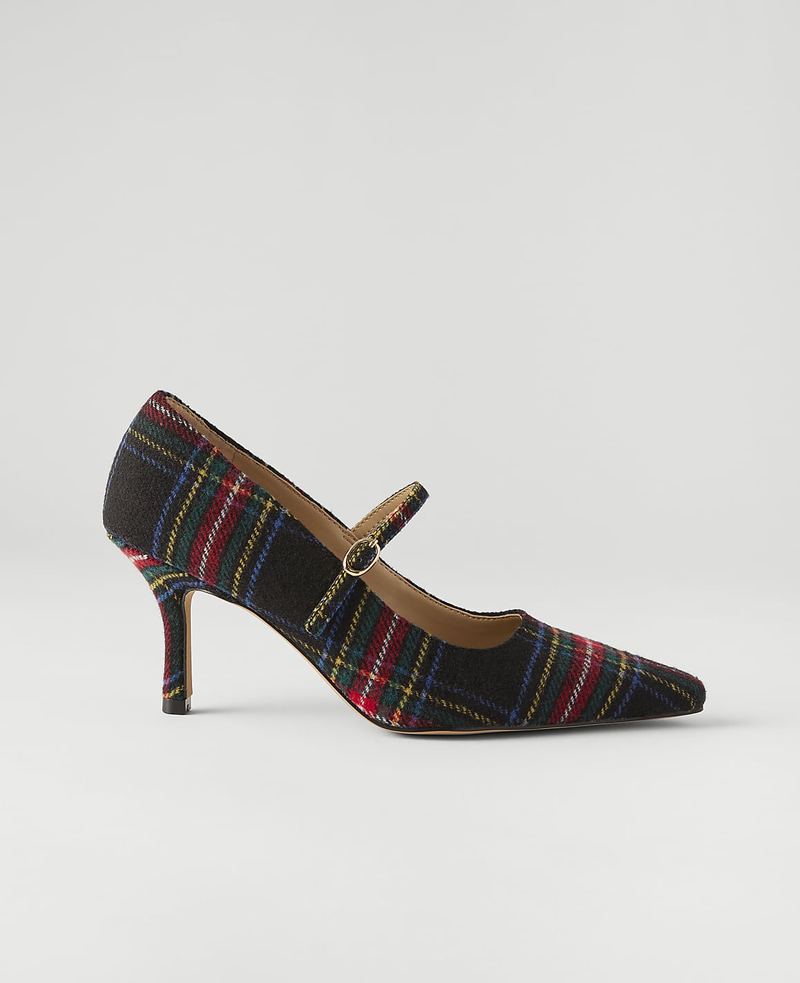 A plaid high-heeled pump with a strap sits centered against a plain, light gray background.