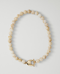 A necklace of pale, marbled beads with a gold clasp rests on a plain white background. carousel Product Image 1