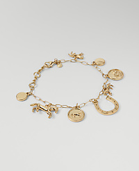 A gold charm bracelet with horse and horseshoe motifs rests on a plain, light gray background. carousel Product Image 1