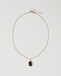 A delicate gold chain necklace with a dark oval pendant rests on a plain white background. carousel Product Image 1