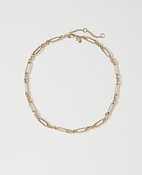 A delicate rose gold chain necklace with elongated oval links rests on a plain white background. carousel Product Image 1