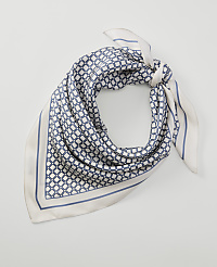 A patterned silk scarf with a geometric design is tied in a knot against a plain white background. carousel Product Image 1