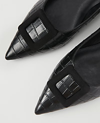 Two black, pointed-toe heels with croc-embossed texture and a square black buckle are laid out on a white background. carousel Product Image 2