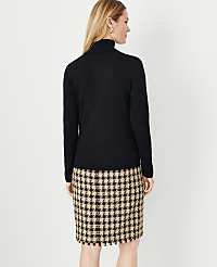 A woman in a black turtleneck and a houndstooth skirt stands against a plain white background. carousel Product Image 2