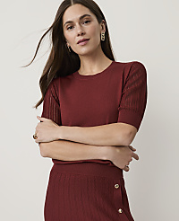 A woman in a maroon knit top and skirt poses with her arms crossed against a plain background. carousel Product Image 1