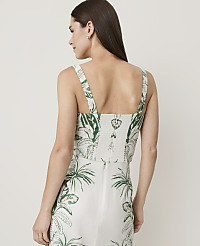 A woman in a white and green tropical print top and skirt stands against a plain white background. carousel Product Image 2