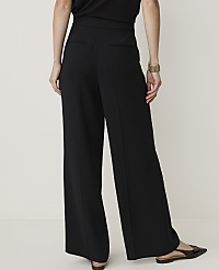 A person wearing black wide-leg pants and pointed-toe flats stands against a plain, light-colored background. carousel Product Image 3