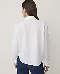 A woman in a white button-down shirt and blue jeans stands against a plain white background. carousel Product Image 2