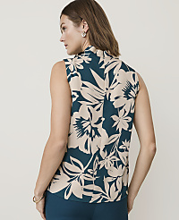 A woman in a sleeveless floral top stands against a plain, light-colored background. carousel Product Image 2
