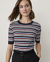 A woman in a striped sweater and black pants stands against a plain, light background. carousel Product Image 1