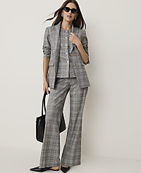 A woman in a grey plaid suit and sunglasses stands with a black tote bag against a plain white background. carousel Product Image 1
