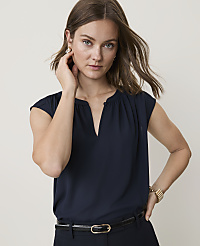 A woman in a navy blouse and black belt poses against a plain, light background. carousel Product Image 1