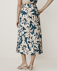 A woman in a floral skirt stands against a plain, light-colored background. carousel Product Image 3