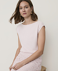 A woman in a light pink top and lace skirt sits against a plain, light background. carousel Product Image 1