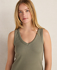 A blonde woman in a green tank top with a textured pattern stands against a plain, light-colored background. carousel Product Image 3