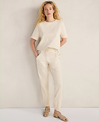 A woman in a cream-colored outfit stands against a textured, light-colored wall. carousel Product Image 3