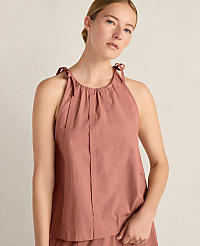 A young woman in a rose-colored halter top with tie straps stands against a plain, light-colored background. carousel Product Image 1
