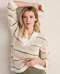 A blonde woman in a striped sweater poses with her arm raised against a textured, light-colored background. carousel Product Image 5