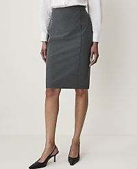 A woman in a grey pencil skirt and white blouse stands against a plain, light grey background. carousel Product Image 2