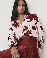 A woman in a light pink floral blouse and a dark red pleated skirt poses against a plain white background. carousel Product Image 3