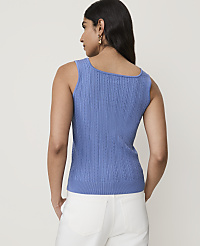 A woman in a blue knit top stands against a plain white background. carousel Product Image 2