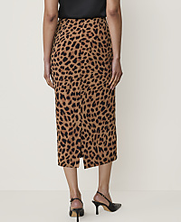 A woman in a leopard print skirt and black heels stands against a plain, light-colored background. carousel Product Image 3