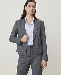 A woman in a grey patterned suit stands against a plain, light-colored background. carousel Product Image 3